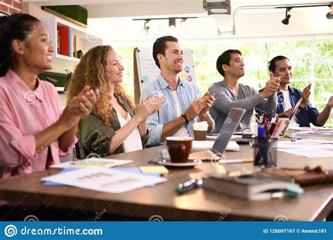 Group Of Business Persons Cheering And Clapping For A Co Worker At The