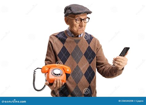 Elderly Man Holding An Old Vintage Rotary Phone And A Smartphone Stock