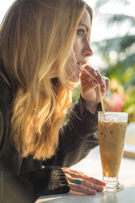woman drinking iced coffee with a straw by stocksy contributor jovo jovanovic stocksy