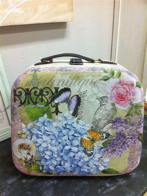 A Suitcase With Flowers And Butterflies Painted On The Front Is Sitting