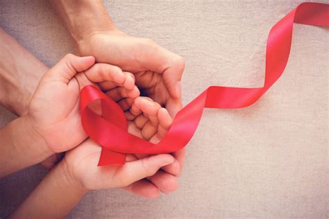 Adult And Child Hands Holding Red Ribbon Hiv Awareness Concept World
