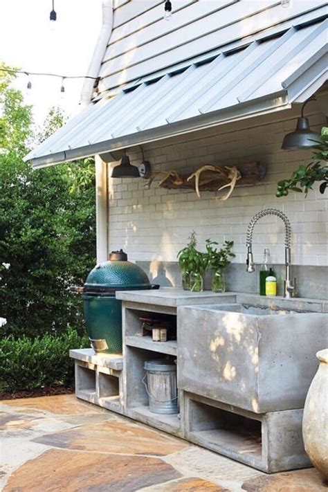 This outdoor kitchen comes with a stainless steel grill, small stove top area, open lower shelving, and an island seating area. Best Outdoor Kitchen Ideas For Your Backyard In 2020 ...
