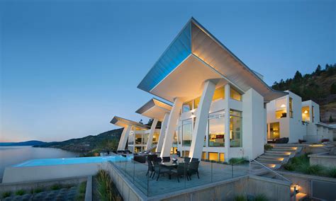 Featuring a concrete home exterior, private pool, and double height living room with airy modern decor. Ultramodern Lake House with Luxurious Details