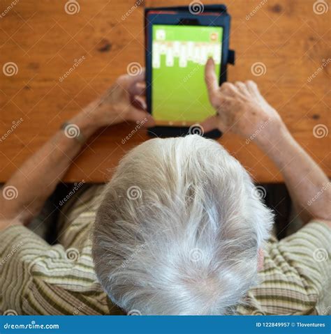 High Angle View Of An Elderly Woman Playing Solitaire On A Table Stock