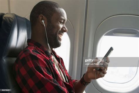 Black Man Listening To Earbuds On Airplane Photo Getty Images