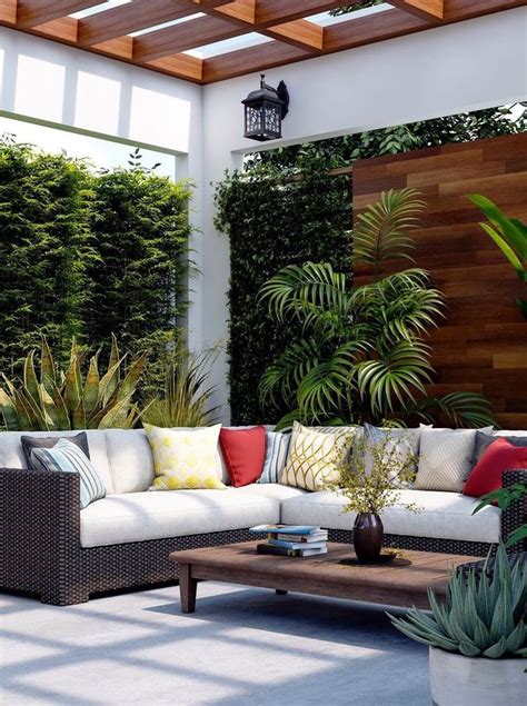 An Outdoor Living Area With Couches Tables And Potted Plants