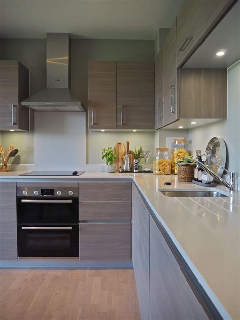 A Modern Kitchen With Stainless Steel Appliances And Wood Flooring On