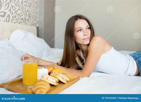 Beautiful Brunette Girl Eating A Healthy Breakfast In Bed Stock Photo
