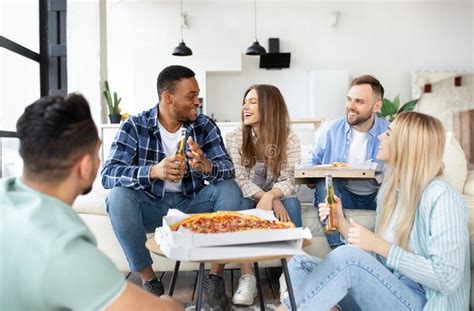 Group Of Happy Interracial Friends Having Party Eating Pizza Drinking Beer Celebrating