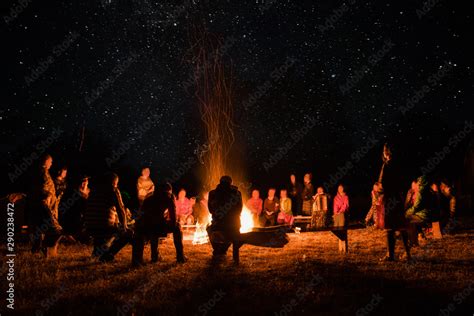 Beautiful Scenery Of Night Vision Bonfire Around People Basking By