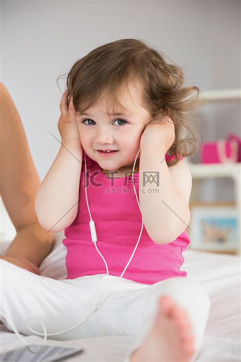 可爱的小女孩在床上听音乐高清摄影大图 千库网