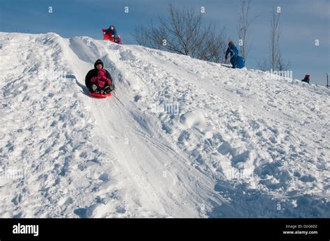 People Sliding Descending On Snow Hill Jarry Park Montreal Canada Stock