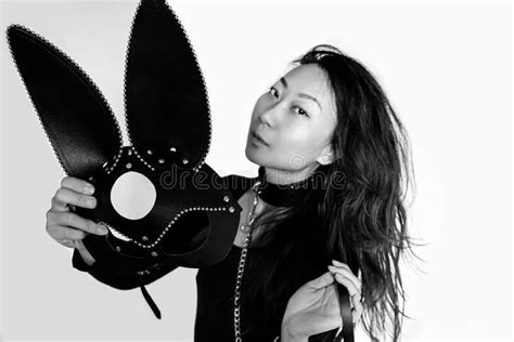 Busty Asian Girl In A Black Bunny Mask Isolated On A White Background