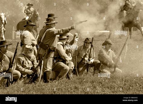 Confederate Soldiers Firing Weapons During A Civil War Re Creation