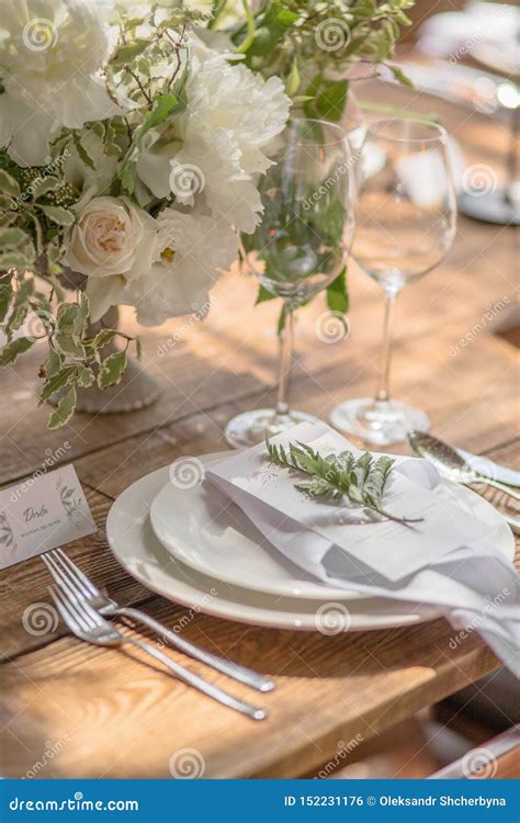 Closeup Of A Table Setting With Rustic Style Flowers For Guests At A