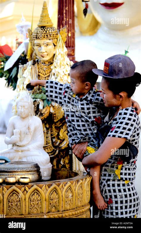 Mother And Baby Make Offerings At A Nat Shrine At The Shwedagon Pagoda
