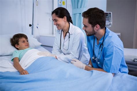 Premium Photo Smiling Doctors Interacting With Patient In Ward