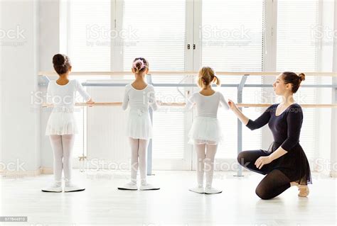 Ballet Teacher Helping Girls With Postures During Ballet Class Stock