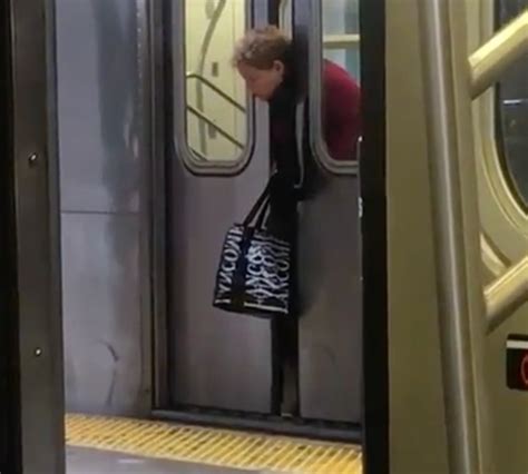 watch nyc subway riders ignore woman with head stuck in doors