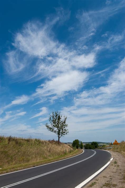 An Empty Country Road Through The Fields On A Sunny Summer Day Stock