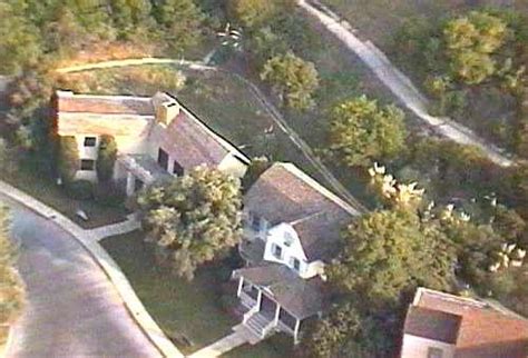 An Aerial View Of A House In The Middle Of A Wooded Area With Lots Of Trees