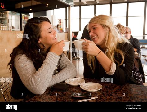 Two Attractive Young Women Drinking Coffee And Talking In A Cafe Paris