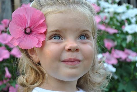 Милая маленькая девочка блондинка с цветком в волосах обои для