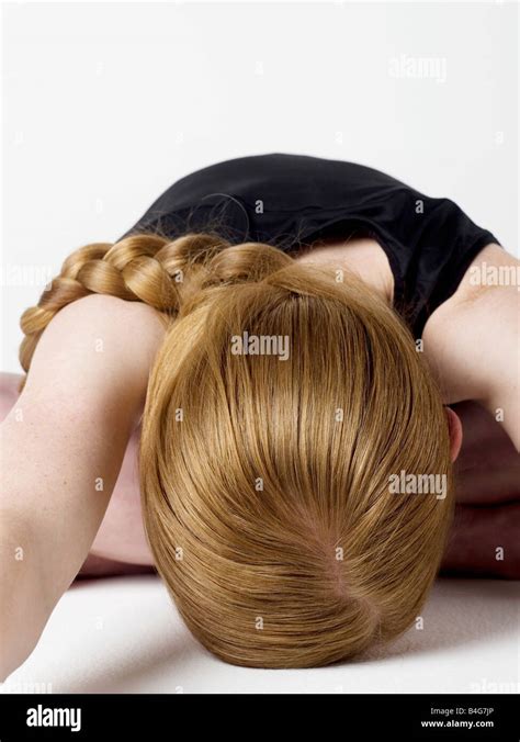 A Young Woman Bending Over And Resting Her Head On The Floor Stock