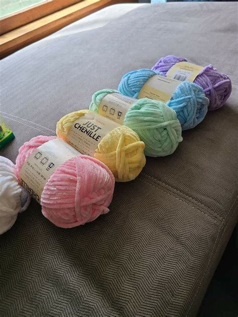 Several Balls Of Yarn Sitting On Top Of A Bed