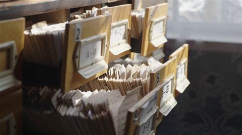 Man opens database drawer. Young librarian opens library card index. Archive, database, library 