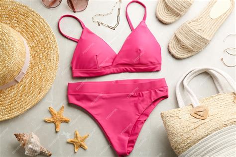 premium photo beautiful pink bikini and beach accessories on light marble background flat lay