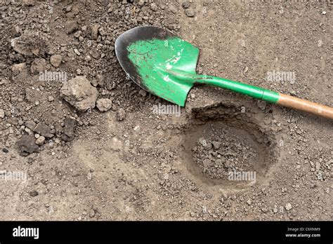 A Hole In The Dirt With Shovel On Ground Stock Photo Alamy
