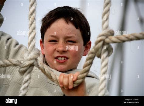 Horizontal Close Up Portrait Of Young Boy Climbing Rope Ladder With