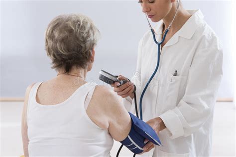 Doctor Measuring Blood Pressure Of Senior Woman Stock Image Image Of