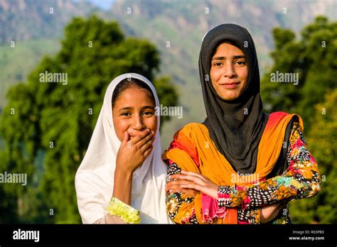 A Portrait Of Two Kashmiri Girls Covering Their Heads By A White And A