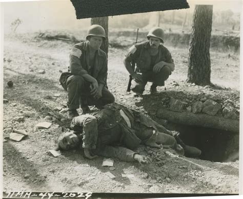 Two American Infantrymen Observing A Dead Nazi Sprawled On The Rim Of