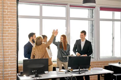 Friendly Team Of Business People Giving High Five To Each Other Stock