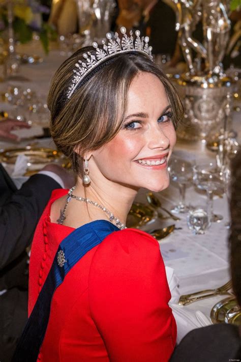 A Woman Wearing A Tiara Sitting At A Table
