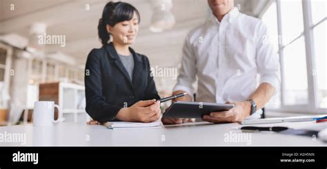 Shot Of Young Business People Using Digital Tablet Device At Work Two