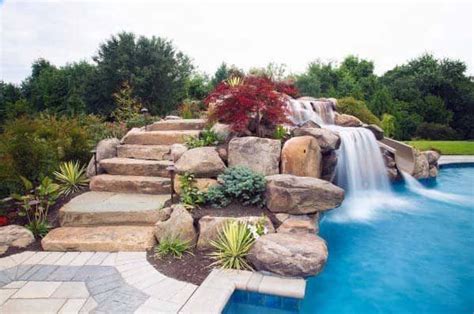 A Pool With Waterfall Rocks And Plants Surrounding It