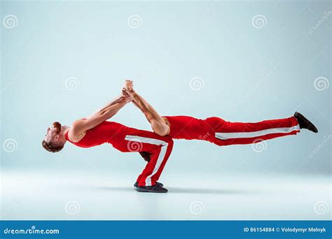 The Two Gymnastic Acrobatic Caucasian Men On Balance Pose Stock Photo