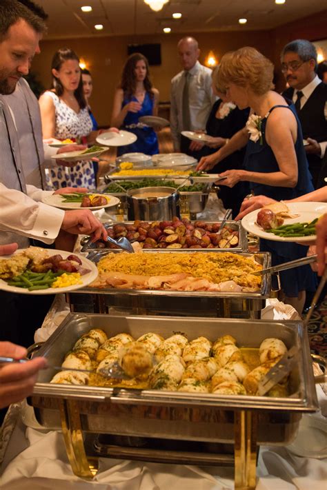 Several People Are Serving Themselves Food At A Buffet