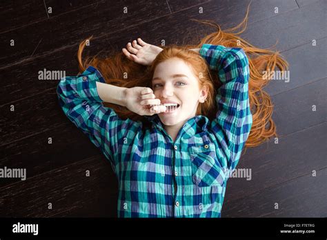 Top View Of Attractive Joyful Redhead Girl In Plaid Shirt Lying On