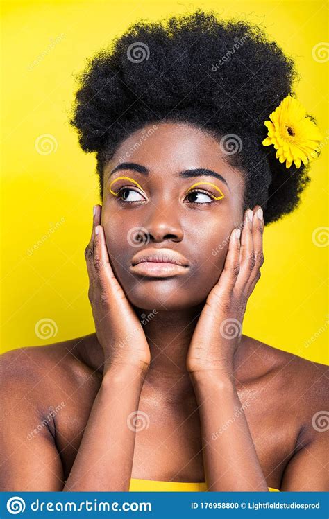 Dreamy African American Woman With Flower In Hair Looking Away Stock