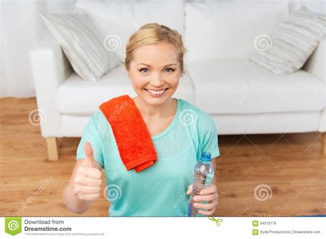 Happy Woman Drinking Water And Exercising At Home Stock