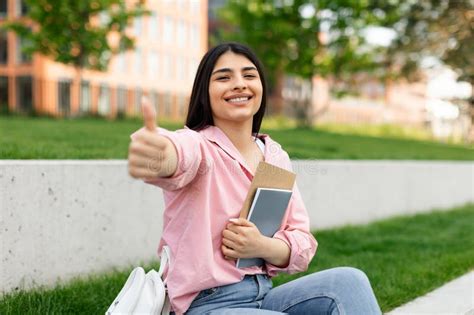 Excited Hispanic Student Lady Gesturing Thumbs Up And Smiling Posing