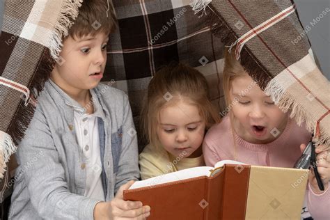 Foto De Niños Leyendo Un Libro En Una Choza