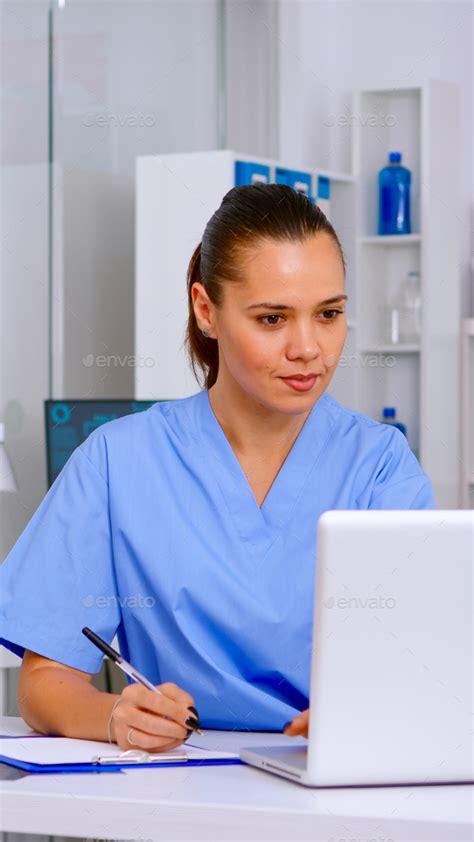 Professional Nurse Writing On Clipboard Patient Health Report Stock