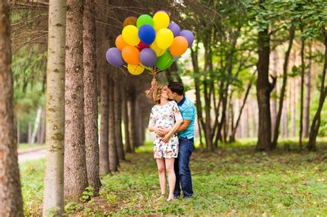 Premium Photo Man And His Pregnant Wife With Balloons Outdoors