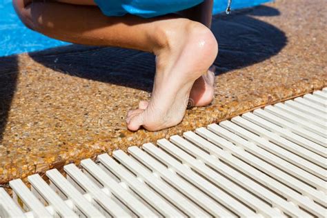 Child Standing Barefoot At The Edge Of A Swimming Pool Stock Image